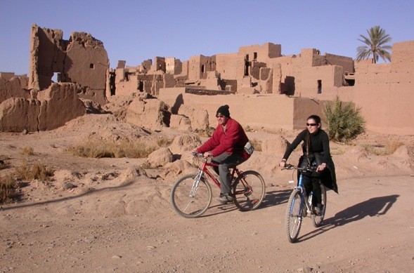 En bici davant el Ksar Asrir de Ferkla (Tinejdad), al Marroc.